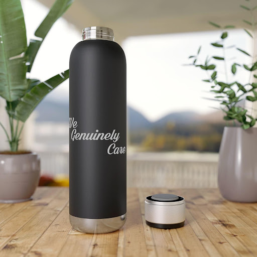 A black water bottle sitting on top of a wooden table.