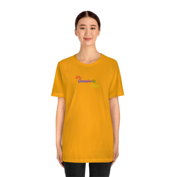 A woman wearing an orange t-shirt with the word " rainbow ".