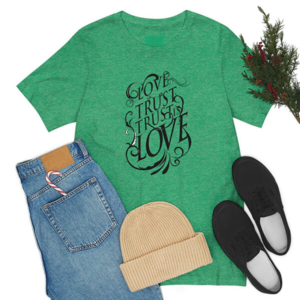 A green shirt and jeans with shoes, hat and plant.