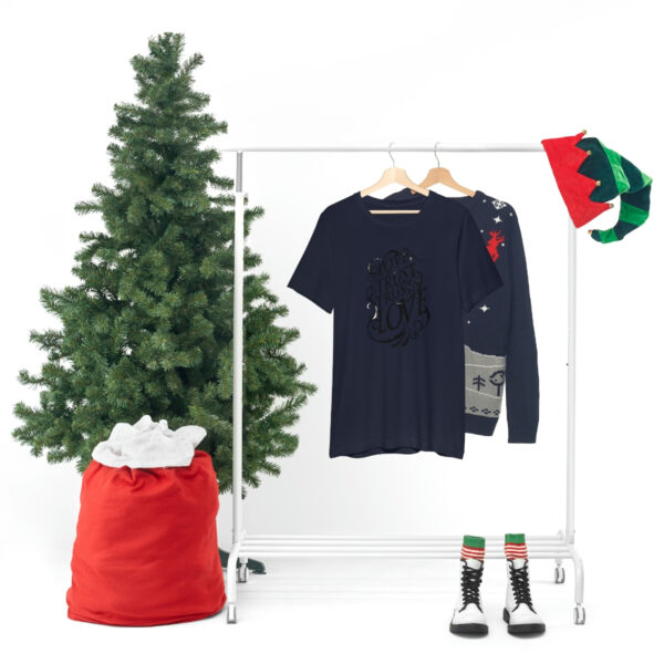 A christmas tree and clothes hanging on a rack.