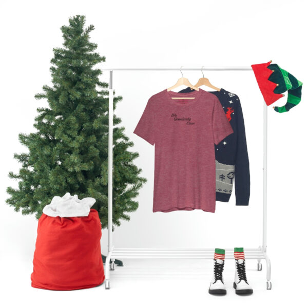 A christmas tree and clothes hanging on a rack.