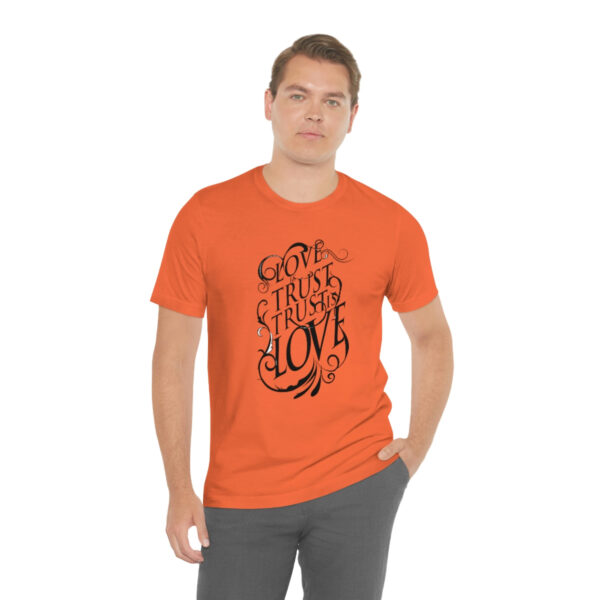 A man wearing an orange t-shirt with the words " trust in hope ".