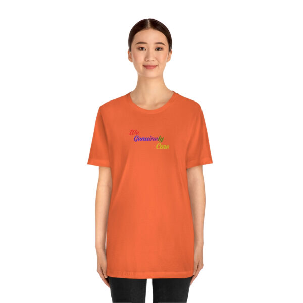 A woman wearing an orange t-shirt with the word " rainbow ".