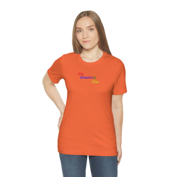 A woman wearing an orange t-shirt with the word " rainbow ".