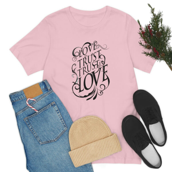 A pink t-shirt with the words " god is trust, he trusts love ".