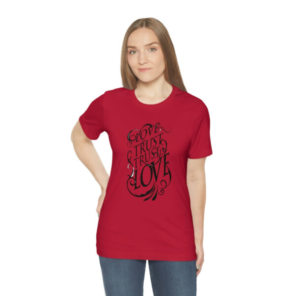 A woman wearing a red t-shirt with an image of a tree.