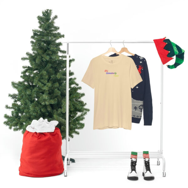 A christmas tree and clothes hanging on a rack.