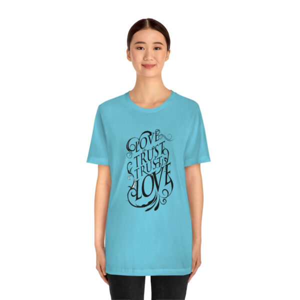 A woman wearing a blue t-shirt with the words " go through love ".