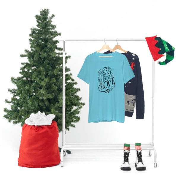 A clothes rack with a t-shirt and a bag of christmas presents.