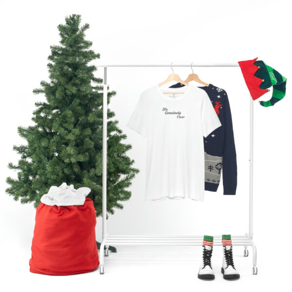 A white clothes rack with a christmas tree and some clothing.