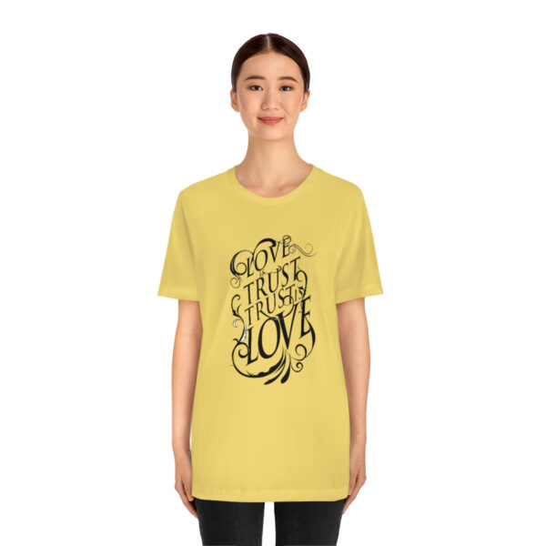 A woman wearing a yellow t-shirt with the words " god is love ".