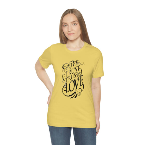 A woman wearing a yellow t-shirt with an image of a tree.