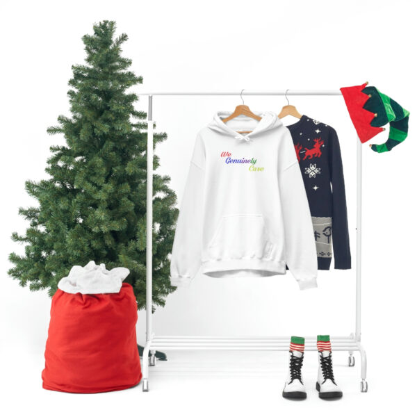 A white clothes rack with a christmas tree and some clothes.