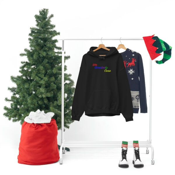 A clothes rack with three different colored sweaters and a christmas tree.