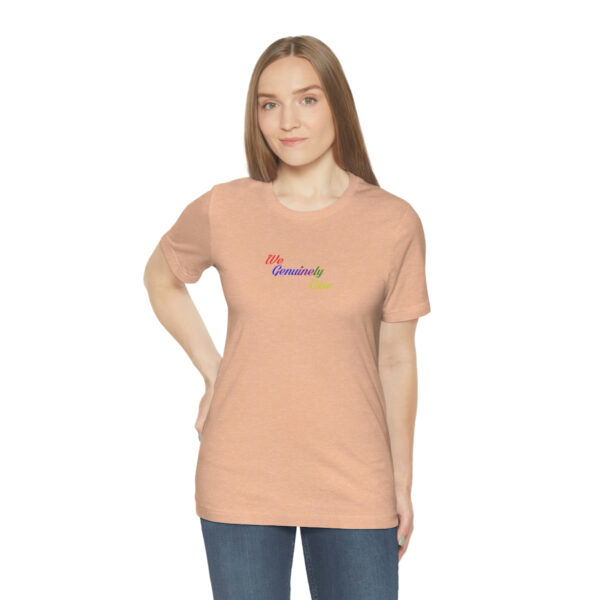 A woman wearing a peach t-shirt with the word " rainbow ".