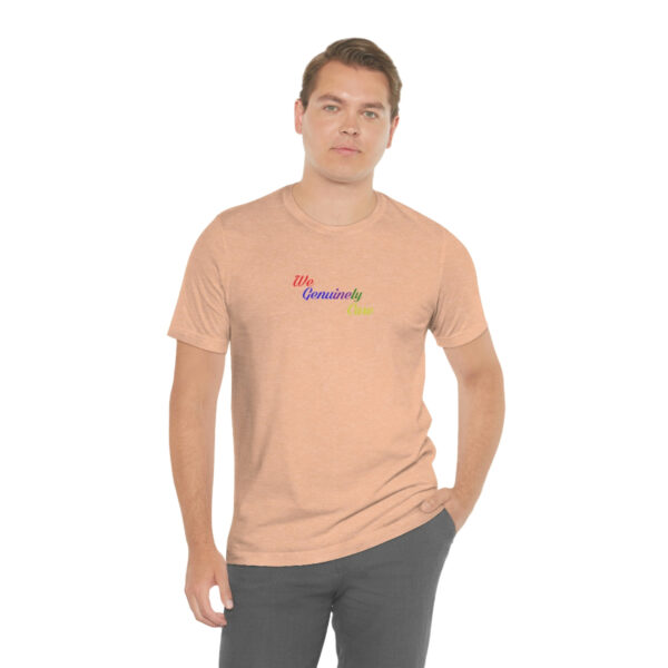 A man standing wearing a peach colored t-shirt.