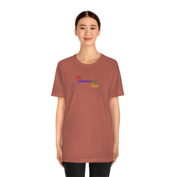 A woman wearing a brown t-shirt with the word " rainbow ".