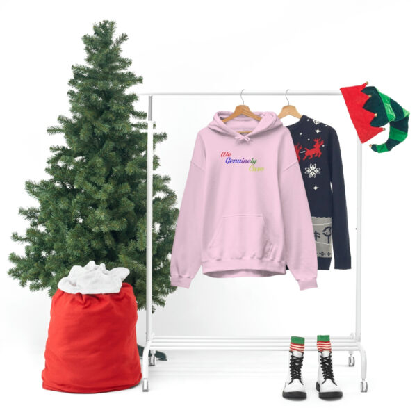 A clothes rack with three different colored sweaters and a christmas tree.