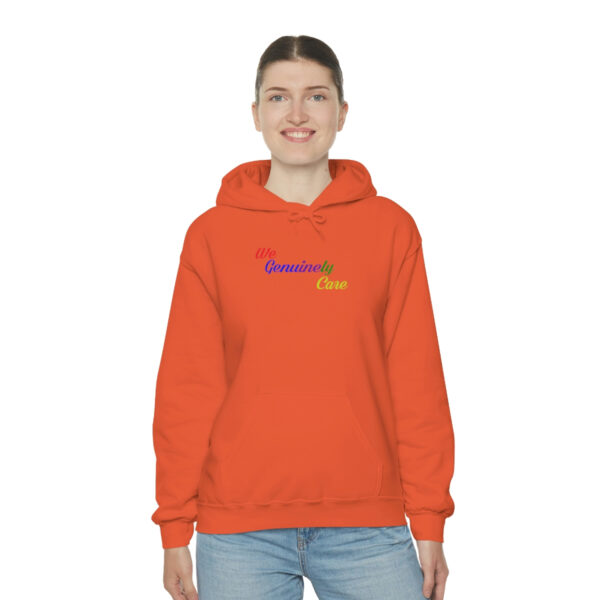 A person wearing an orange hoodie with the word " rainbow ".