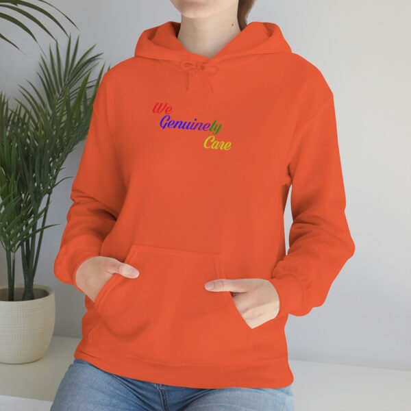 A person wearing an orange hoodie with the words " rainbow one ".