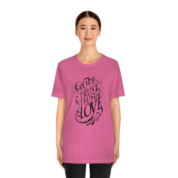 A woman wearing a pink t-shirt with the words " go through love ".