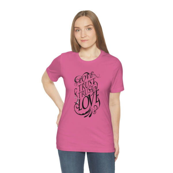 A woman wearing a pink t-shirt with an image of a tree.