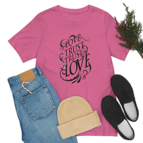 A pink t-shirt with the words " god is trust in love ".