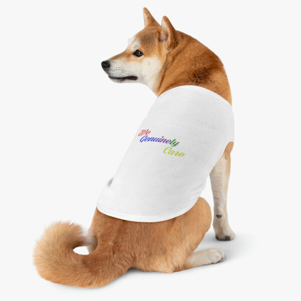 A dog sitting on its back legs wearing a shirt.