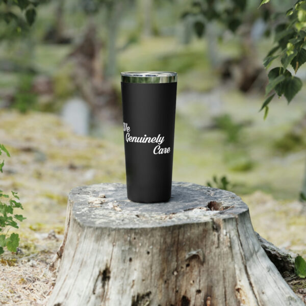 A black cup sitting on top of a tree stump.