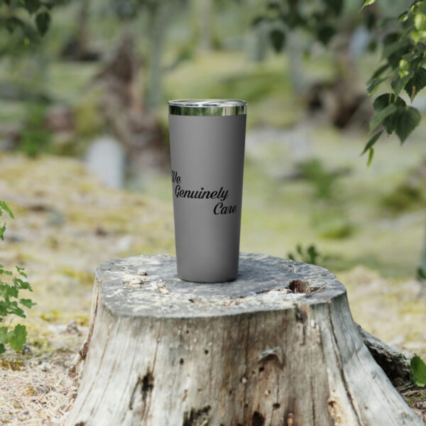 A stainless steel cup sitting on top of a tree stump.