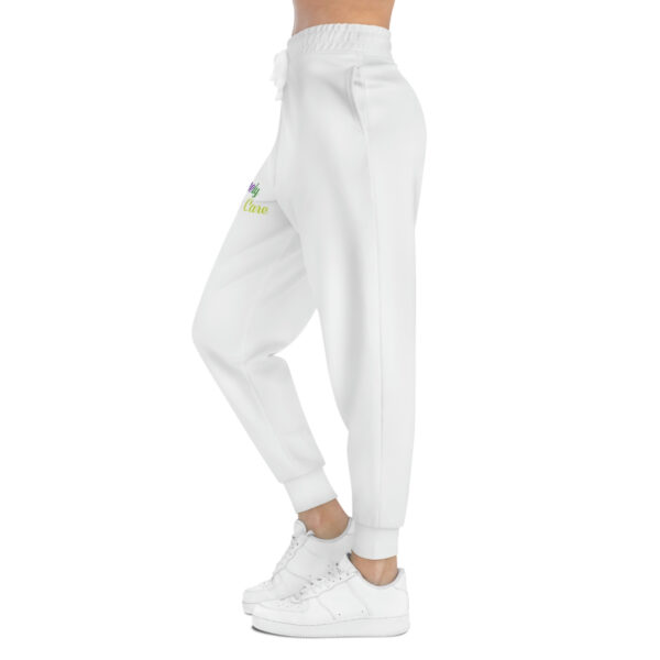 A woman wearing white sweatpants with a green and yellow logo.