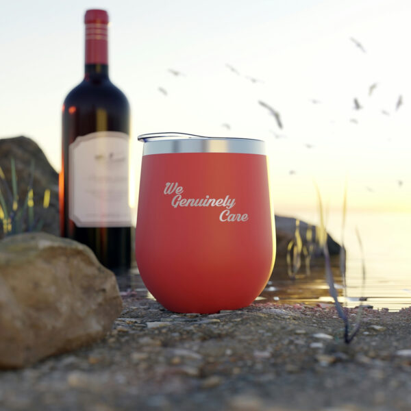 A red wine glass sitting on top of the ground.