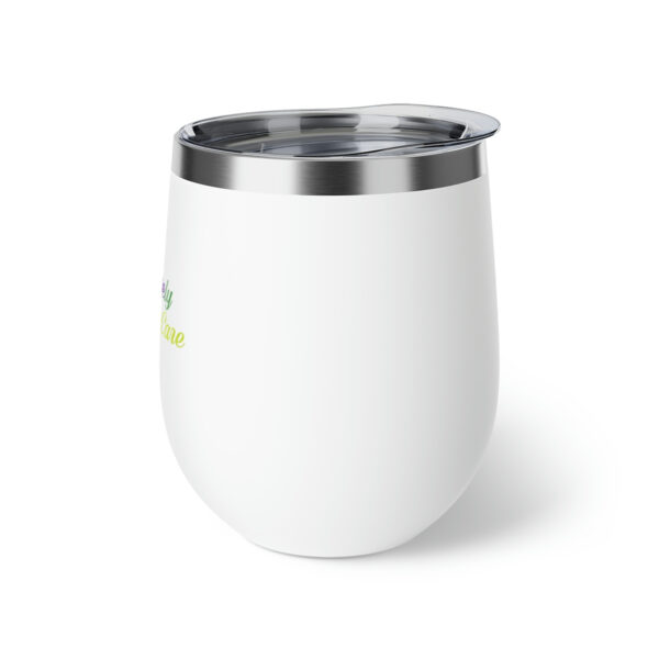 A white cup with a green and yellow design on it.