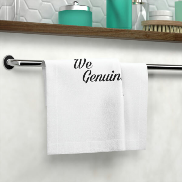 A towel hanging on the wall with the words " we genuin " written on it.