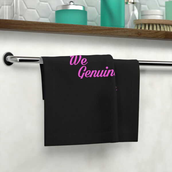 A towel hanging on the wall with the words " we genuin " written on it.