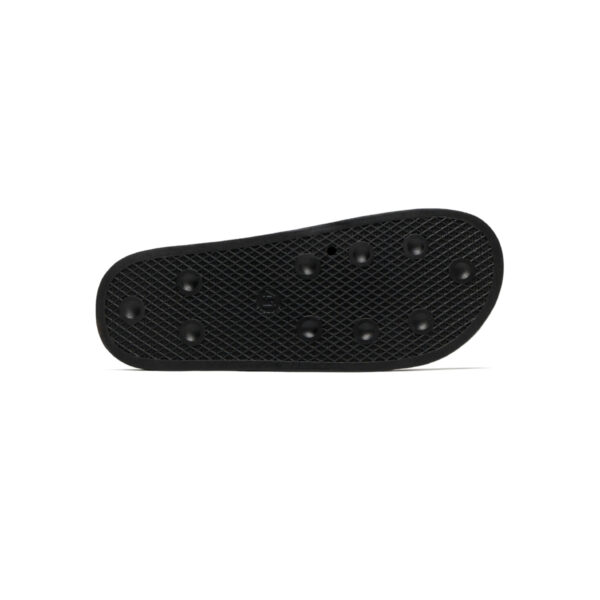A black flip flop with holes in it.