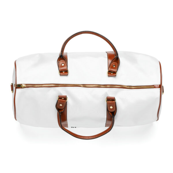 A white duffel bag with brown leather handles.