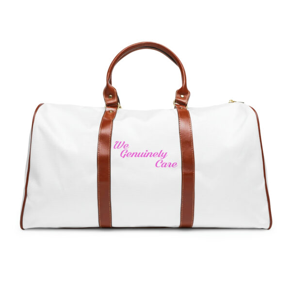 A white duffel bag with brown leather handles and a pink embroidered logo.