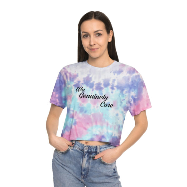 A woman wearing jeans and a tie dye shirt.