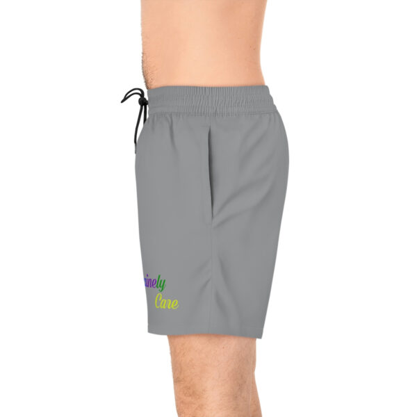 A man wearing grey swim trunks with rainbow logo.