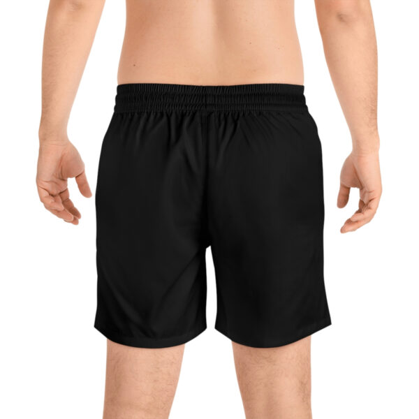 A man wearing black shorts with white writing on it.