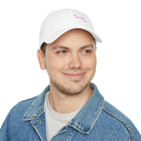 A man wearing a white hat with pink lettering.