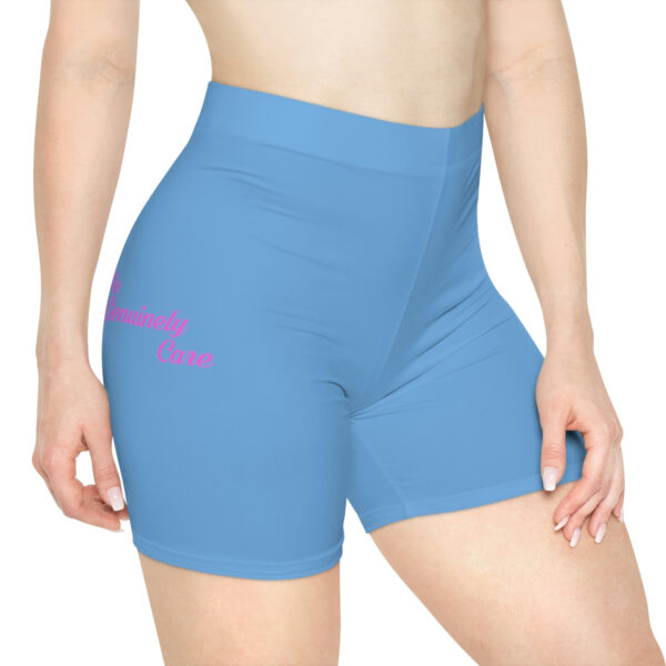 A woman wearing blue shorts with pink writing on it.